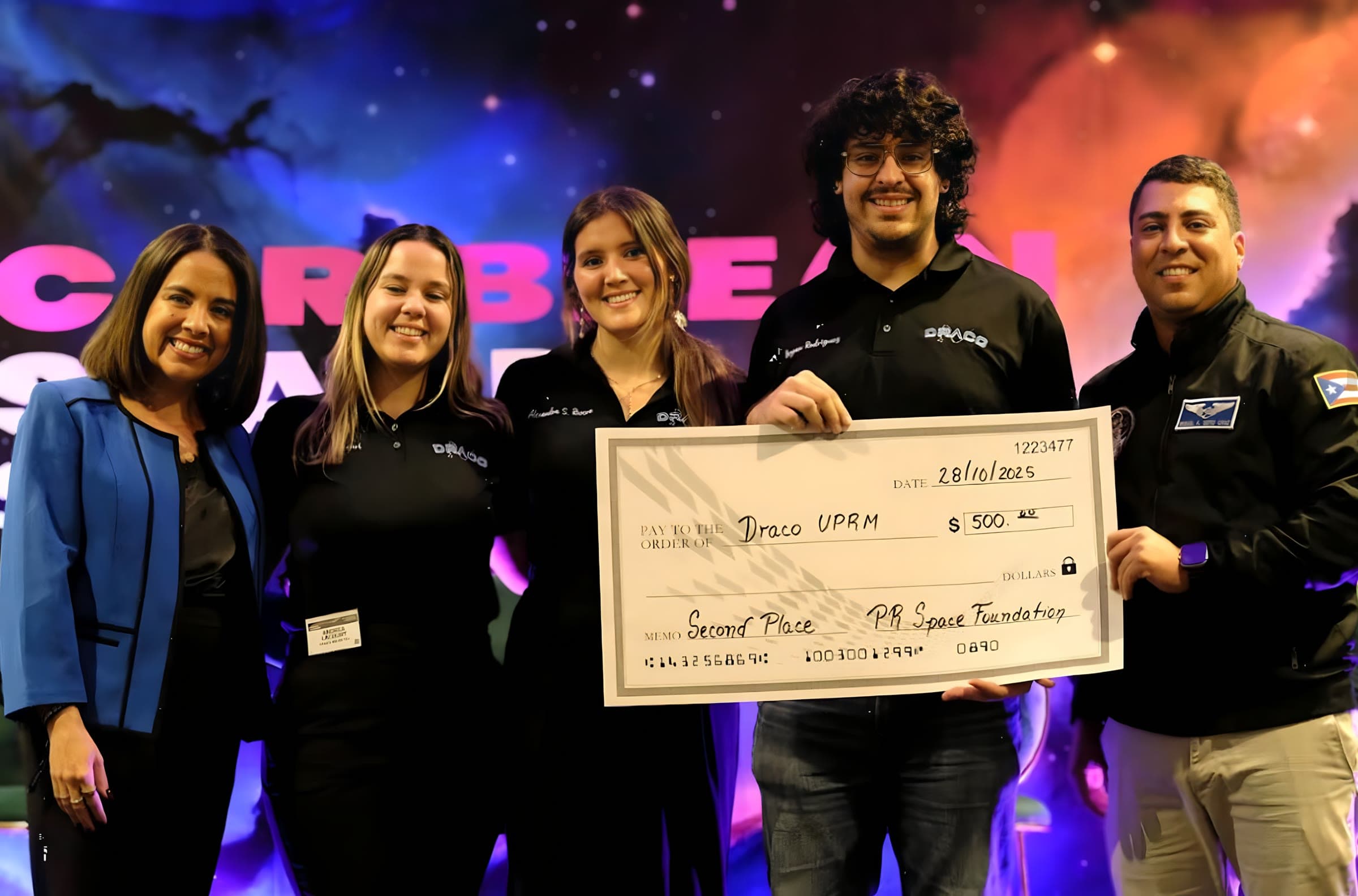 DRACO members receiving an oversized award cheque on stage at the Caribbean Space Summit