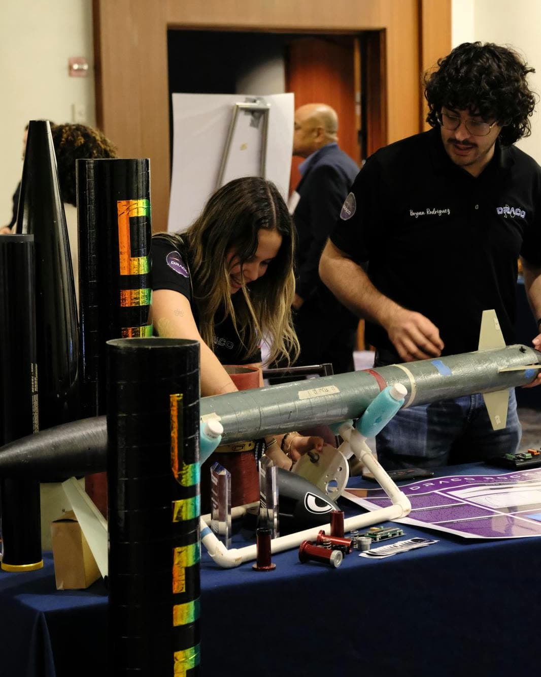 DRACO members setting up rocket hardware and awards at their table during the Caribbean Space Summit