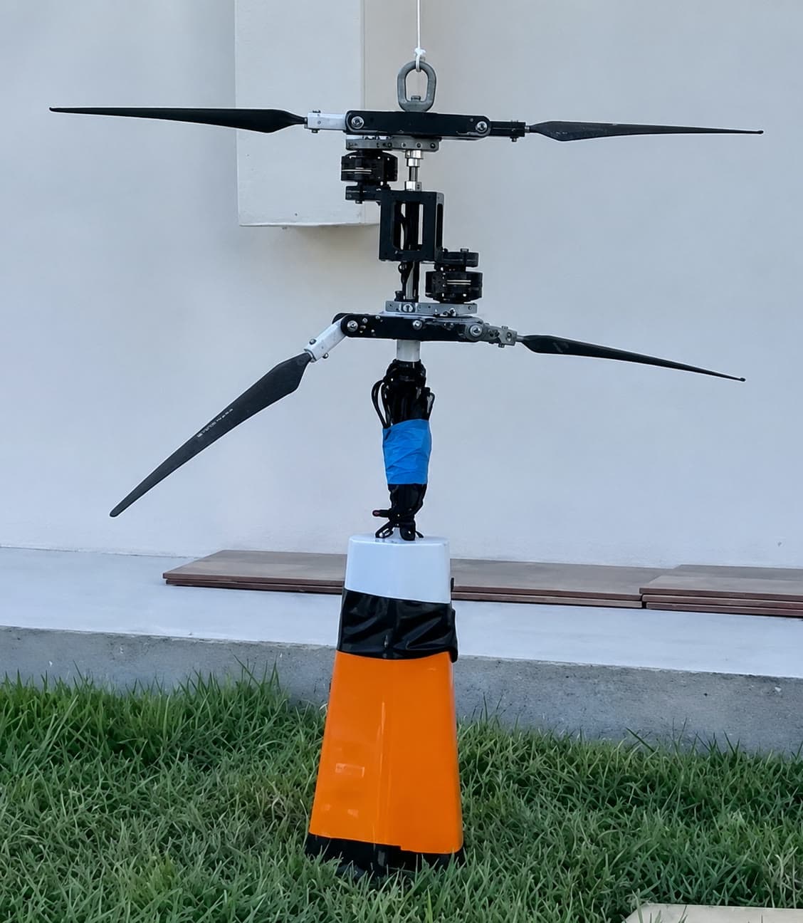 Coaxial helicopter payload with two counter-rotating rotor sets on a single shaft, standing on a cone during ground testing